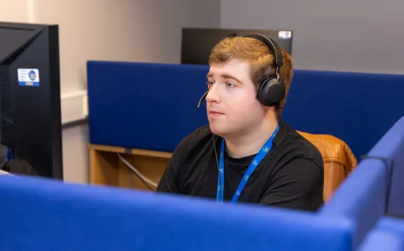 Male adviser taking a call with headset on