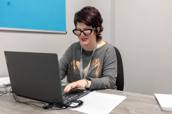 Adviser working at desk on laptop